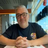 man wearing glasses with hands crossed.