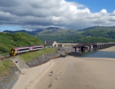 A train near Barmouth viaduct travelling between the mountains and coast.