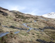 Dau feiciwr mynydd yn reidio i lawr llwybr troellog yn Antur Stiniog.