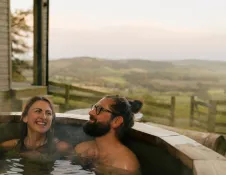 woman and man in hot tub with view of countryside.