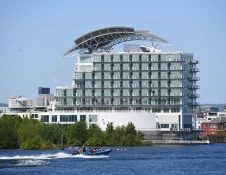 large modern hotel and boat on water.