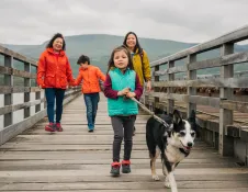 Teulu a'i ci yn cerdded ar draw pont Abermaw 