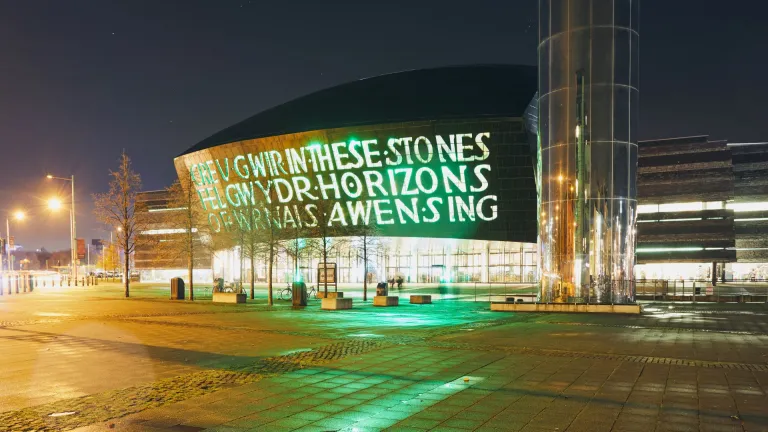 Exterior of Wales Millennium Centre and the water tower on Roald Dahl pass at night.