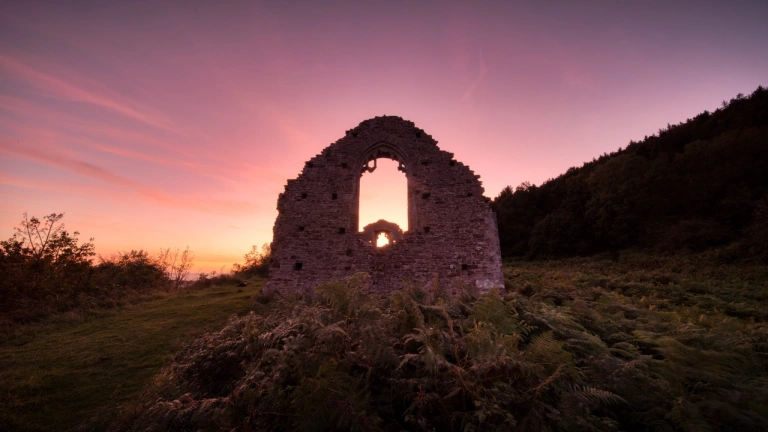 Heulwen y gwyll y tu cefn i adfeilion hen gapel 