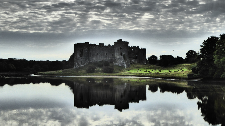 Golygfa o gastell Caeriw ger aber Cleddau gyda chymylau yn adlewyrchu yn yr afon.
