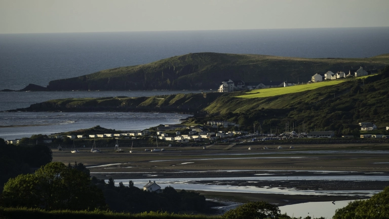 Aber afon Teifi gan edrych dros bentref i gyfeiriad y môr.
