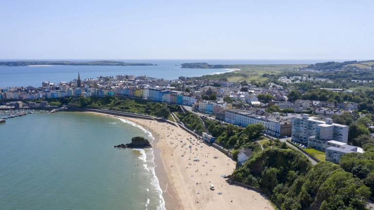 Golygfa o'r traeth a'r dref o'r awyr.