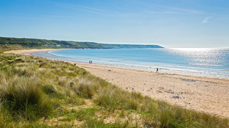 Traeth, gyda thwyni tywod yn y tu blaen, a'r môr yn y cefndir