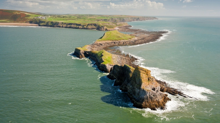 Golygfa o'r awyr o Ben Pyrod yn ymestyn allan i'r môr