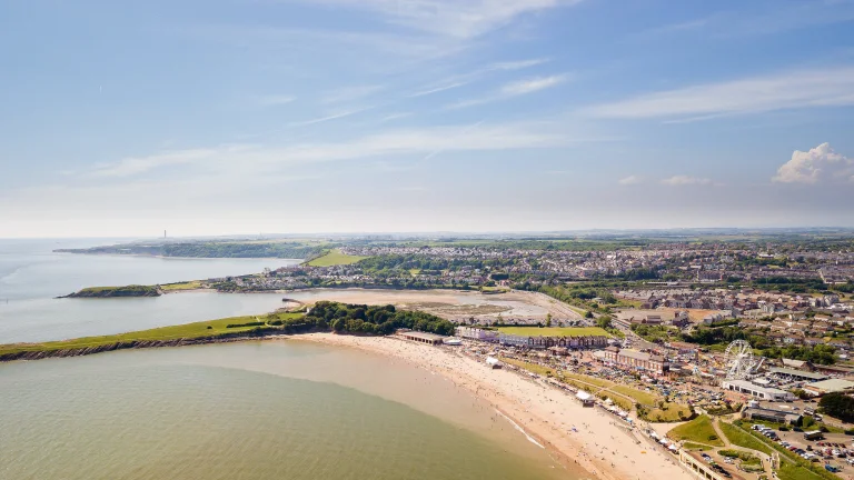 Golygfa yn edrych dros Ynys y Barri gyda awyr las a'r môr