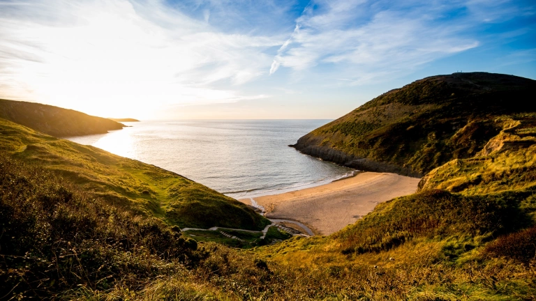 Golygfa o'r traeth wrth i'r haul fachlud