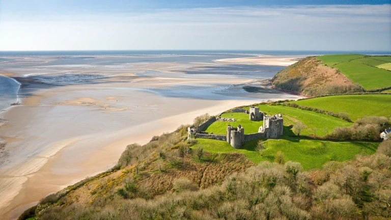 Llun oddi fry o gastell Llansteffan yn edrych dros y môr