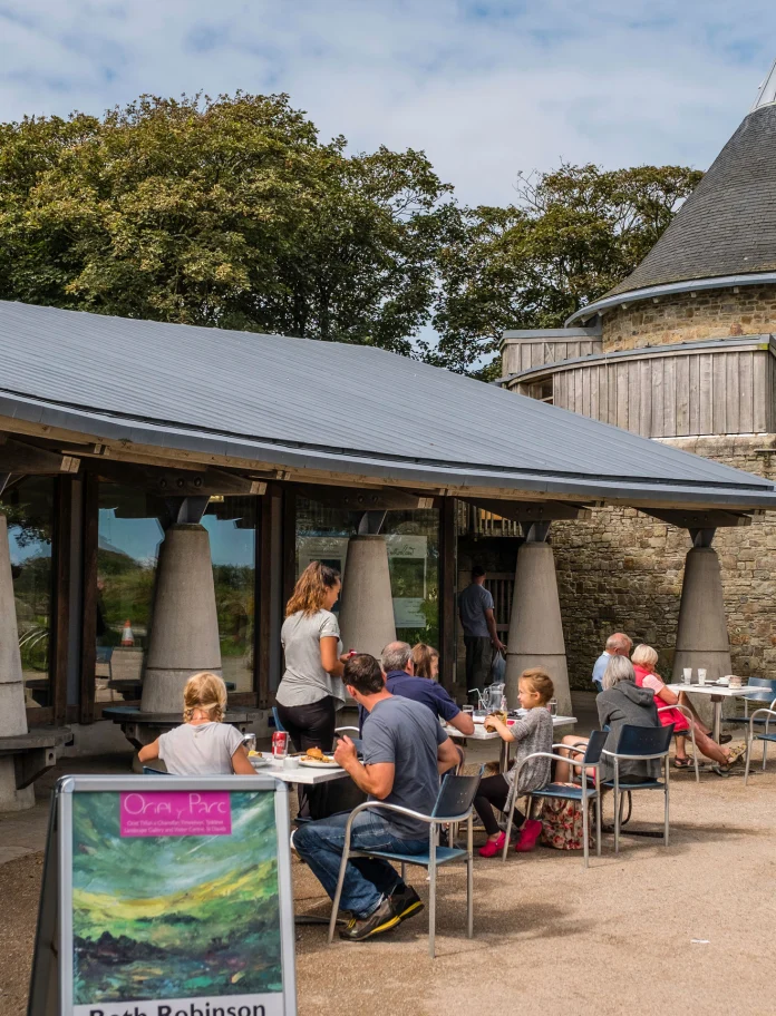 Pobl yn eistedd tu allan i Oriel y Parc, Tyddewi