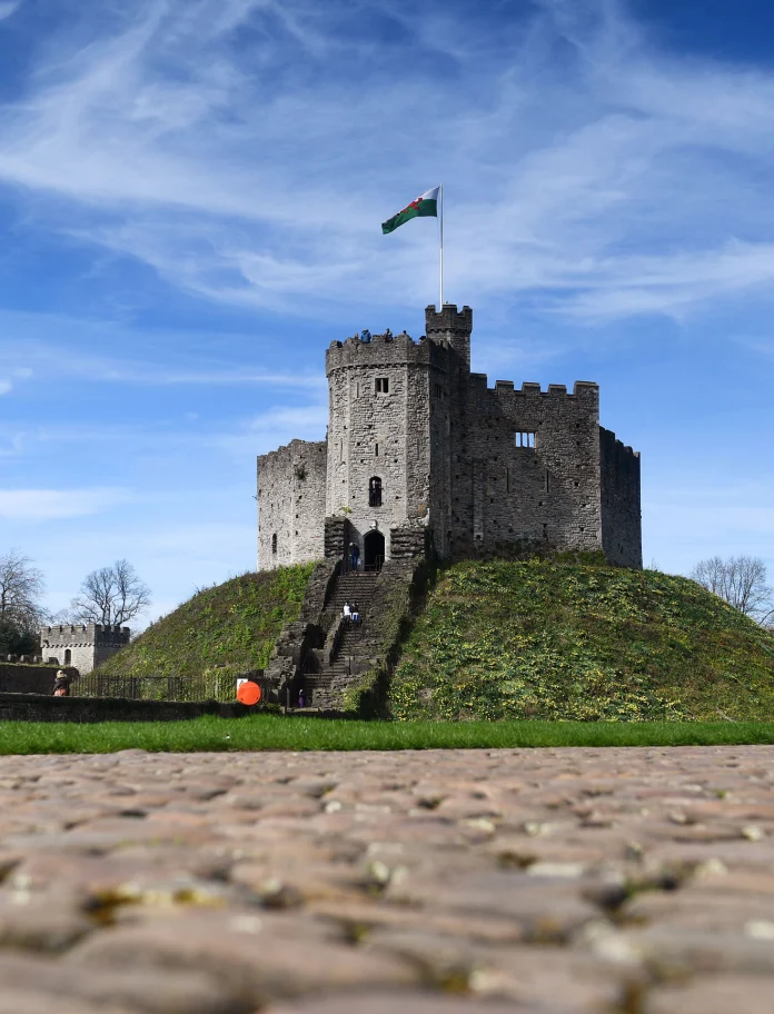 Llun o dŵr y castell gyda baner Cymru yn hedfan