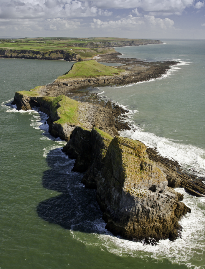 Golygfa o'r awyr o Ben Pyrod yn ymestyn allan i'r môr