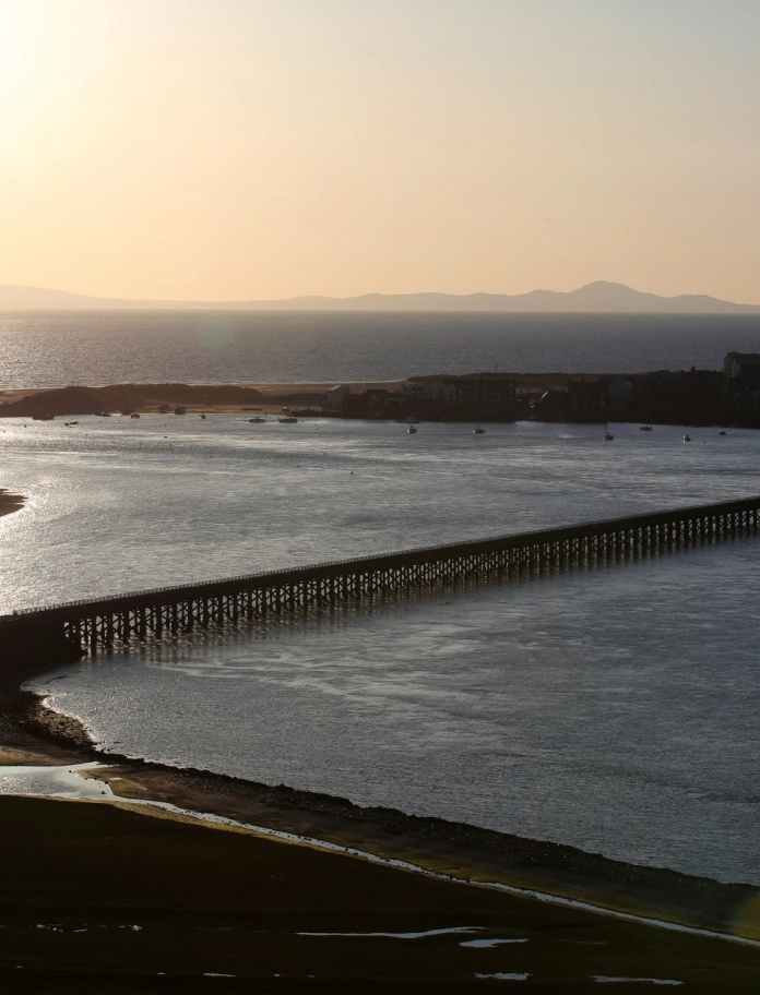 Pont Abermaw wrth iddi fachlud yn edrych draw tuag at y môr