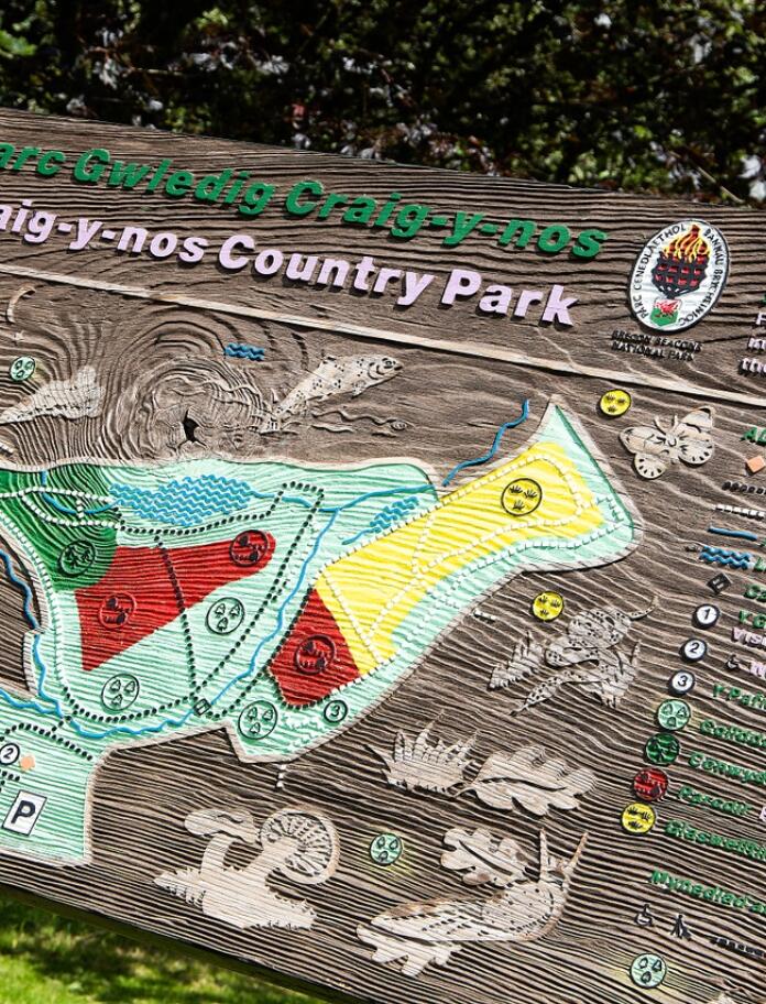 Arwydd pren a map Parc Gwledig Craig-y-Nos.