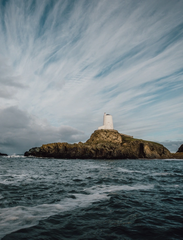 Llun o'r goleudy ar y graig yn y môr