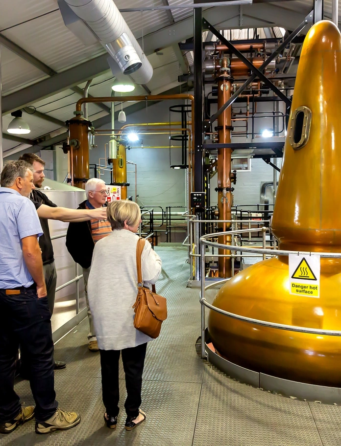 Grŵp o ymwelwyr ar daith Distyllfa Penderyn