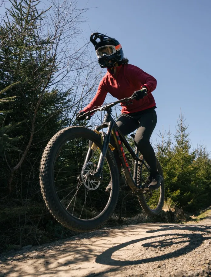 person yn neidio ar feic mynydd mewn parc beiciau.