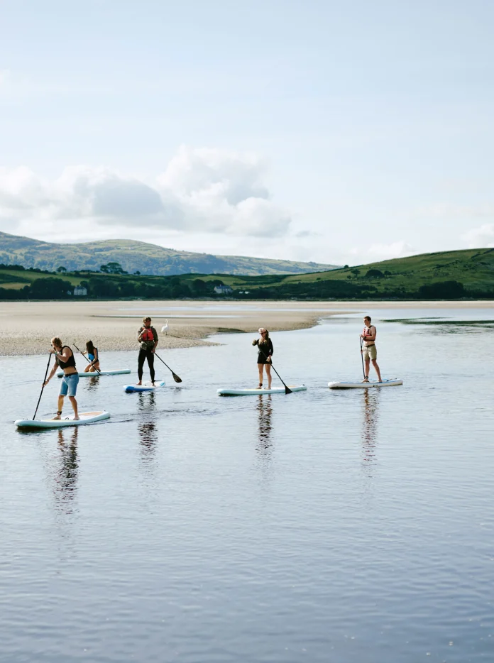 Chwech person yn padlfyrddio ar Afon Dwyryd