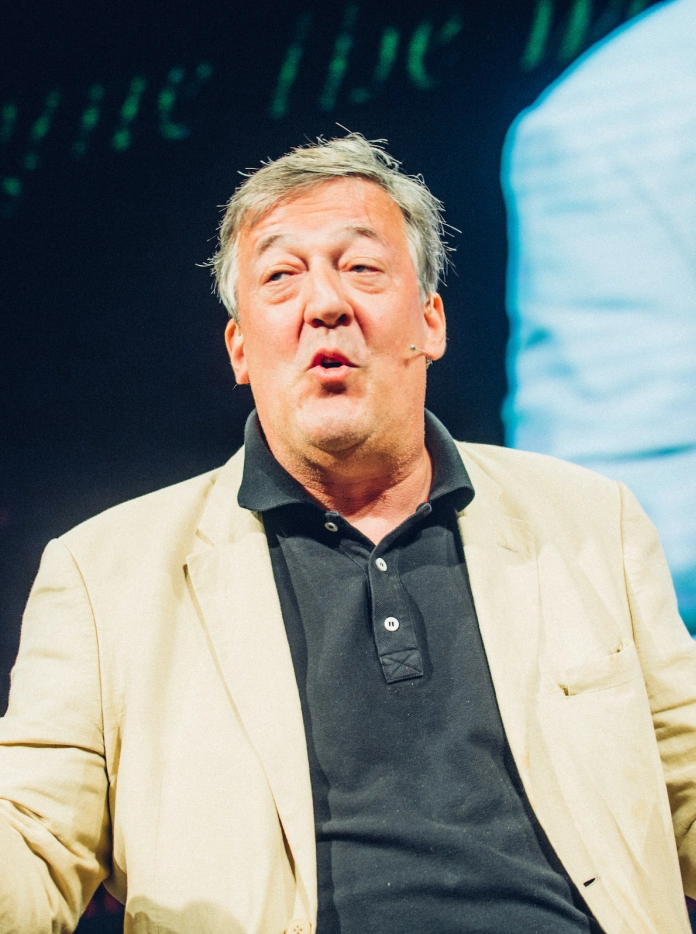 Stephen Fry yn siarad o'r llwyfan