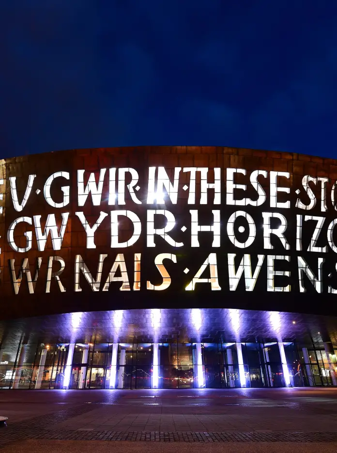 Adeilad celfyddydau mawr wedi’i oleuo gyda’r nos.