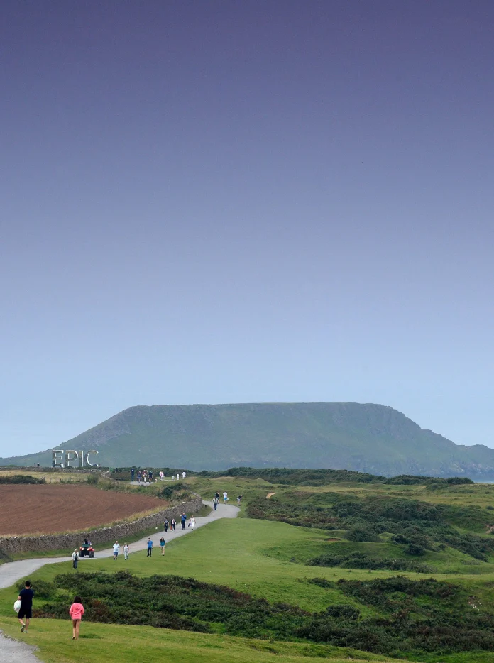 Pobl yn cerdded tuag at yr arfordir