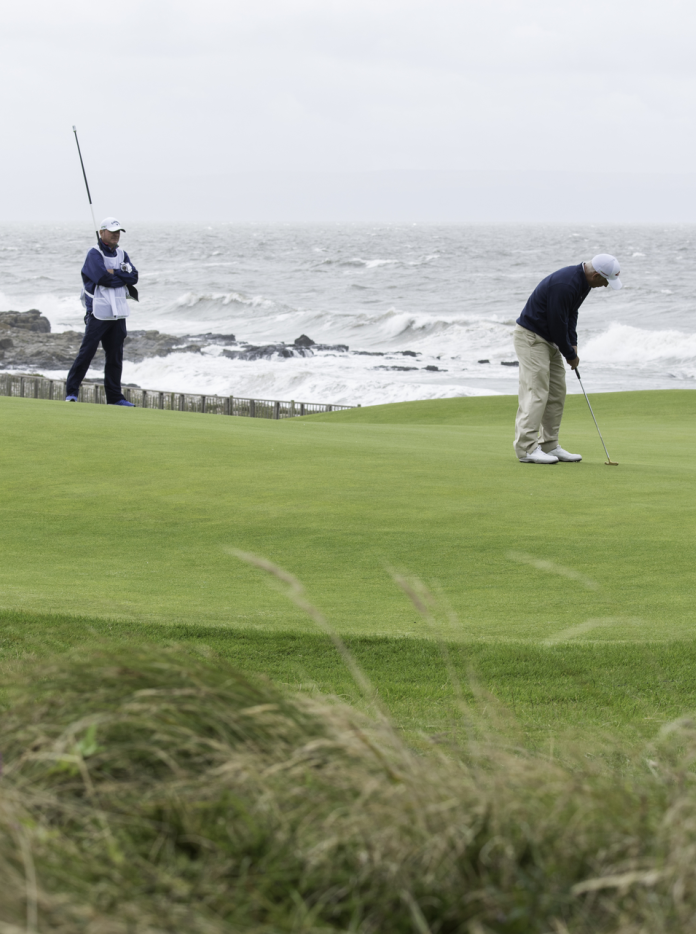 3 o bobl yn chwarae golff wrth ymyl y môr
