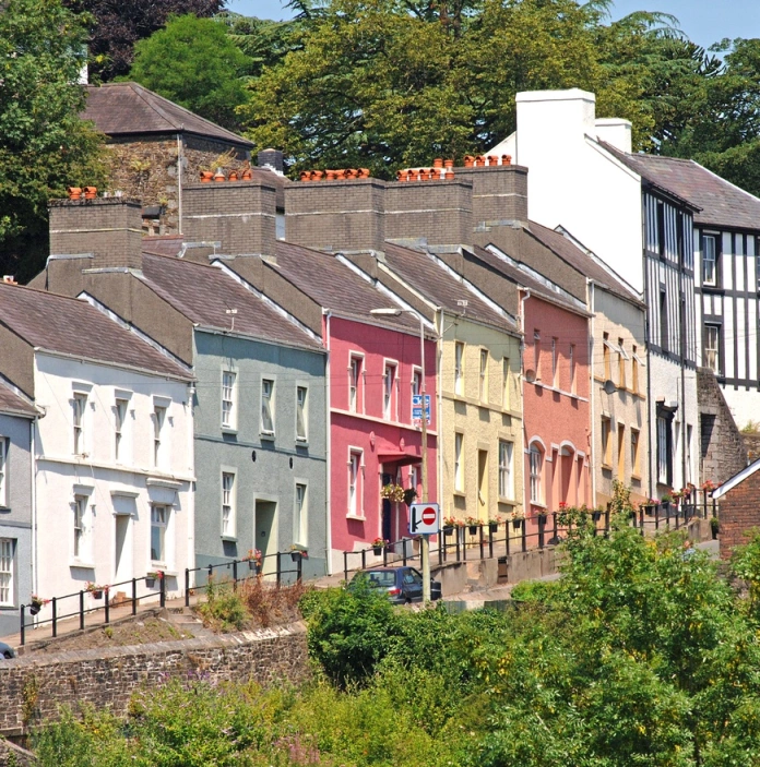 Stryd o dai lliwgar ar allt. Mae tai pinc, melyn, oren a gwyrdd.