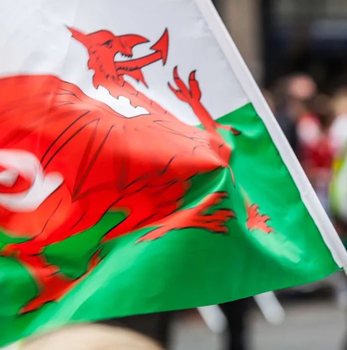 Mae’r faner Gymreig yn chwifio yn y gwynt