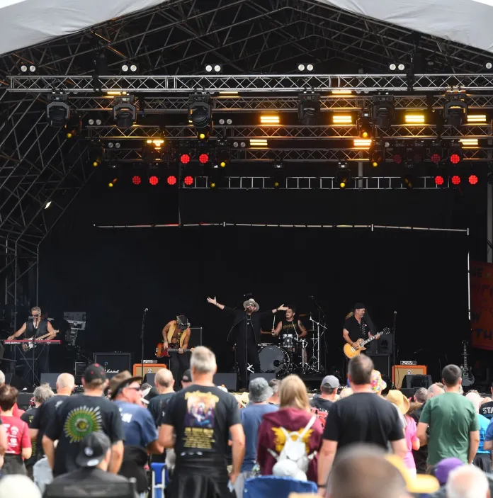 a crowd of people facing a festival stage.