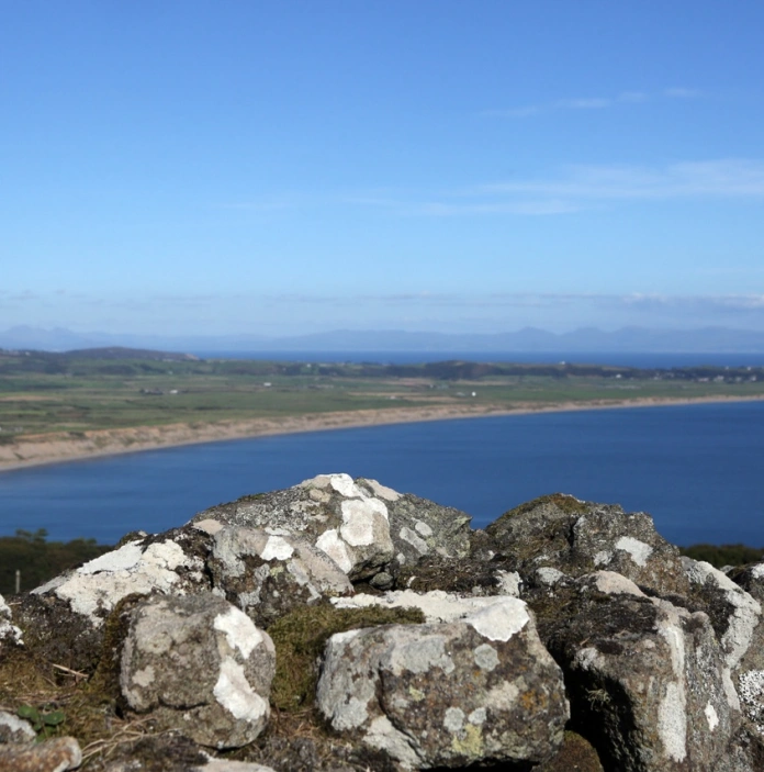 Golygfa o'r môr a'r llinell lan o'r creigiau ar dir uchel