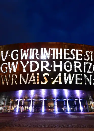Adeilad celfyddydau mawr wedi’i oleuo gyda’r nos.