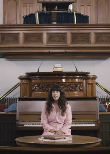 Y gantores Lisa Jên yn eistedd o flaen y piano yng Nghapel Jerusalem ym Methesda