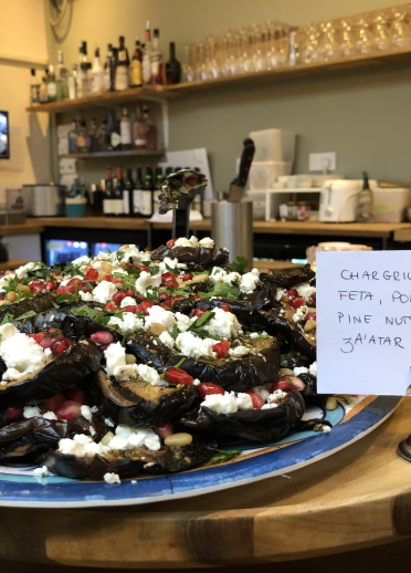 Plate of aubergine, feta, pomegranate, pine nuts, parsley and za'atar