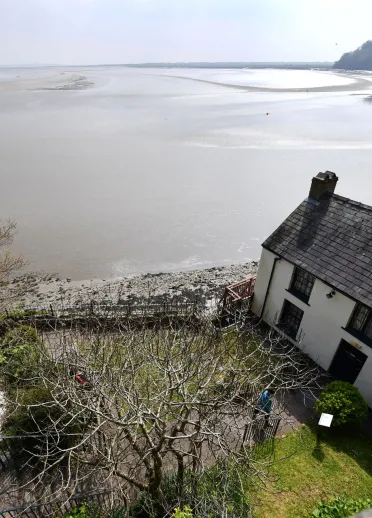 Bwthyn gwyn a gardd ger y môr