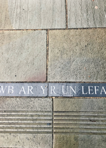 'Pawb ar yr un Lefel', ysgrifen ar y pafin ym Mlaenau Ffestiniog