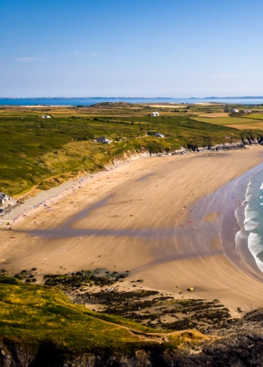 Traeth llydan, tywodlyd a welir oddi uchod.