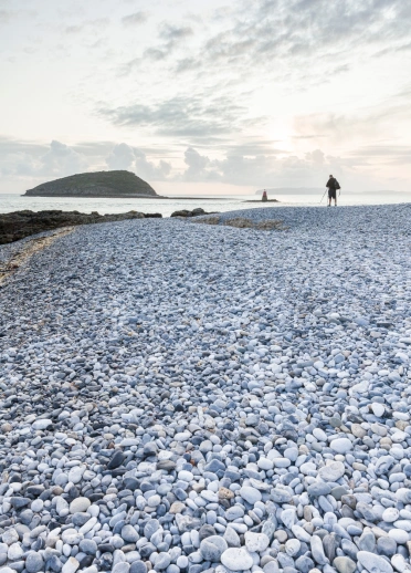 Tir pengrwn traeth gyda rhai cerddwyr yn y pellter
