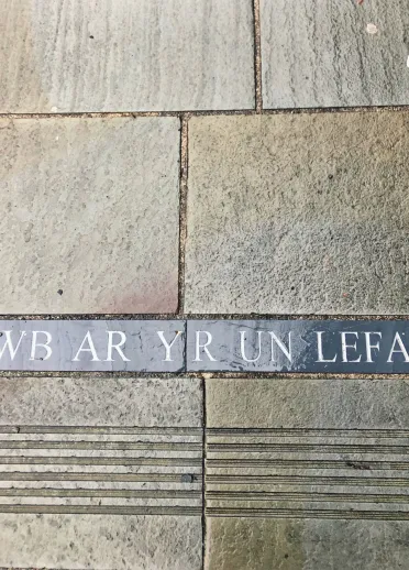'Pawb ar yr un Lefel', ysgrifen ar y pafin ym Mlaenau Ffestiniog