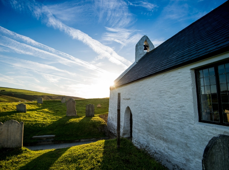 Llun heulog o ochr yr eglwys fechan wedi gwyngalchu