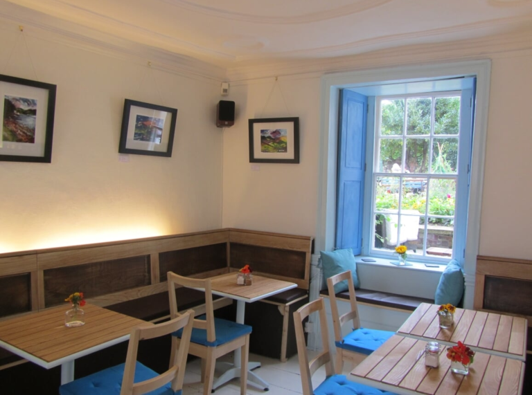 Llun o fyrddau a chadeiriau tu mewn i Fig Tree Espresso