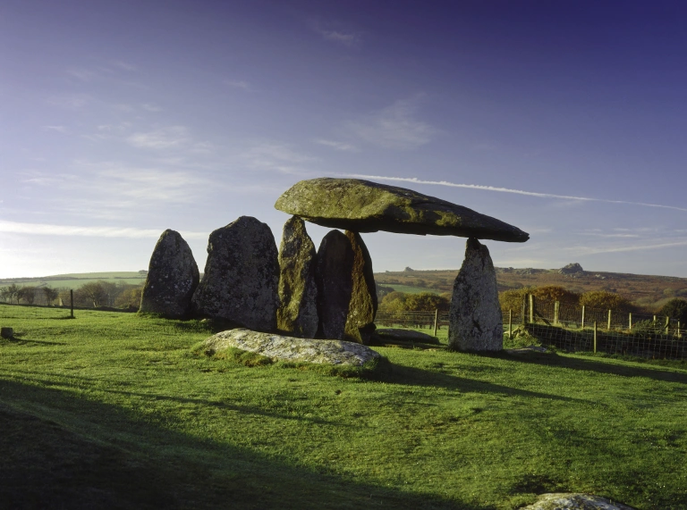 Siambr gladdu cerrig cerrig gyda golygfa o gefn gwlad.