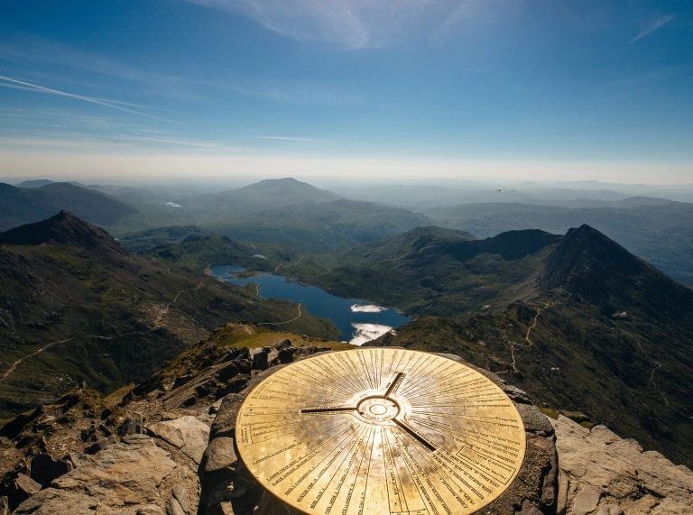 Copa'r Wyddfa yn edrych allan dros lyn a mynyddoedd