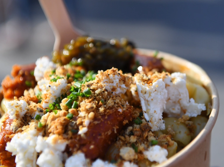 Pot o salad ffeta gyda sifys wedi’i daenu ar ei ben.