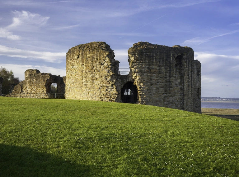 Adfeilion castell ar ymyl glaswellt
