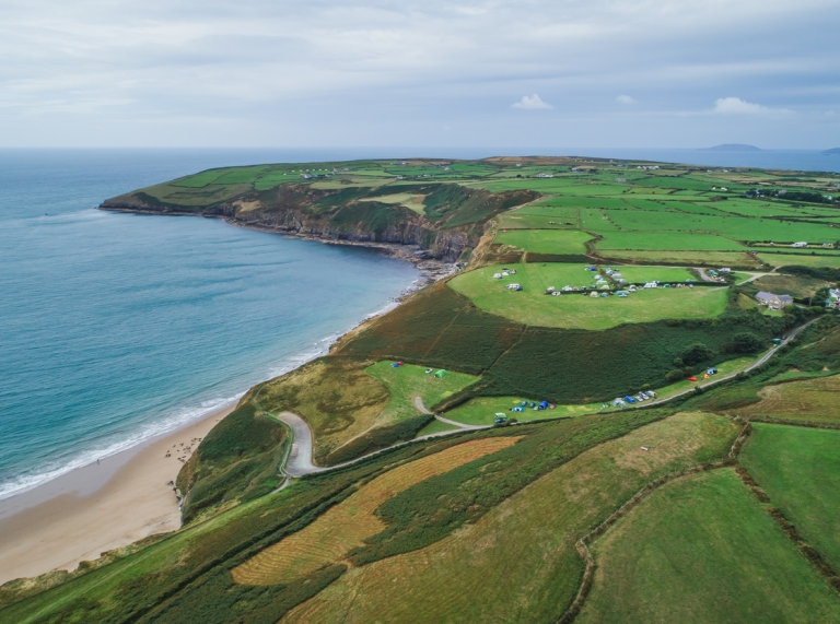 golygfa o’r awyr o draeth a phenrhyn.