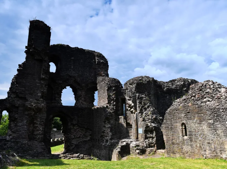 Adfeilion castell ar ddiwrnod heulog.