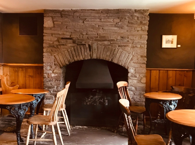 Tu mewn i fwyty gyda thân mawr yn ganolbwynt.